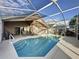 Beautiful pool with a screened-in lanai, a grill, and a seating area at 1717 Clubhouse Cv, Haines City, FL 33844