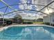 Screened-in pool with clear blue water and views of the surrounding landscape at 1717 Clubhouse Cv, Haines City, FL 33844