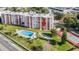 Aerial view showcasing condo building, pool, and tennis court at 1776 6Th St Nw # 209, Winter Haven, FL 33881