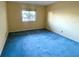 Bright bedroom featuring blue carpet and window at 1776 6Th St Nw # 209, Winter Haven, FL 33881
