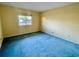 Spacious bedroom with blue carpeting and a window at 1776 6Th St Nw # 209, Winter Haven, FL 33881