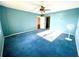 Spacious bedroom with blue carpet and ceiling fan at 1776 6Th St Nw # 209, Winter Haven, FL 33881