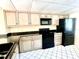 Modern kitchen featuring black appliances and granite counters at 1776 6Th St Nw # 209, Winter Haven, FL 33881