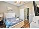 Bright bedroom with a white bed frame and wood flooring, access to bathroom at 2143 Calabria Ave, Davenport, FL 33897