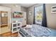Well-lit bedroom with a white bed frame and wood flooring, access to bathroom at 2143 Calabria Ave, Davenport, FL 33897
