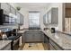 Modern kitchen with gray cabinets, granite countertops, and stainless steel appliances at 2143 Calabria Ave, Davenport, FL 33897