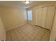 Simple bedroom with tile floors and double door closet at 2332 Prime Cir # B, Kissimmee, FL 34746