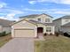 Two-story house with a brick driveway and landscaped lawn at 256 Lancaster Dr, Davenport, FL 33897