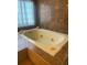 A large bathroom with a tiled jacuzzi tub and a window providing natural light at 2681 Robin Ave, Kissimmee, FL 34744
