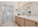 Bright bathroom with a double sink vanity, large mirror, and a glass-enclosed shower with tiled walls at 2993 Stillwater Dr, Kissimmee, FL 34743