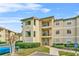 Condo building with walkway, landscaping, and parking at 3036 Parkway Blvd # 104, Kissimmee, FL 34747