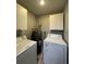 Convenient laundry room with washer, dryer, and overhead cabinets at 3036 Parkway Blvd # 104, Kissimmee, FL 34747