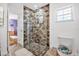 Modern bathroom with a glass shower, stone tile, and white toilet at 306 Boger N Blvd, Lakeland, FL 33803