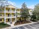 Three-story yellow building with balconies, landscaping, and parking at 312 Lucaya Loop # B5/U312, Davenport, FL 33897
