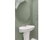 Small powder room with pedestal sink and oval mirror at 4078 Malawi Trl, Saint Cloud, FL 34772