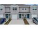 Three-unit townhome building with gray exterior, two-car garages, and landscaping at 4078 Malawi Trl, Saint Cloud, FL 34772