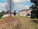 View of a spacious backyard featuring a white fence, a patio with chairs, and green space at 4858 Stone Acres Cir, St Cloud, FL 34771