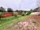 Lush backyard featuring a brick wall, mature trees, and verdant grass at 4858 Stone Acres Cir, St Cloud, FL 34771