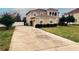 Two-story home boasting an arched balcony, manicured landscaping, and a long driveway at 4858 Stone Acres Cir, St Cloud, FL 34771