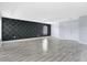 Spacious living room featuring sleek wood floors and a statement wallpaper accent wall at 4858 Stone Acres Cir, St Cloud, FL 34771