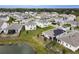 Aerial view of homes with solar panels, manicured lawns, and a serene pond at 5052 Center Ct, St Cloud, FL 34772