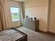 Well-lit bedroom with a dresser and a view of a lake at 5052 Center Ct, St Cloud, FL 34772