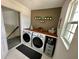 Functional laundry room featuring modern appliances, a wooden countertop, and ample storage at 5052 Center Ct, St Cloud, FL 34772