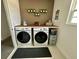 Well-organized laundry room with modern appliances, wooden countertop, and decorative shelves at 5052 Center Ct, St Cloud, FL 34772