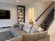 Living room with gray sofa, built-in shelving and staircase at 5052 Center Ct, St Cloud, FL 34772