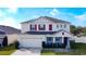 Two-story house with gray siding, red shutters, and a two-car garage at 524 Sardinia Cir, Davenport, FL 33837