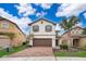 Two-story house with brown garage door and brick driveway, surrounded by palm trees at 5505 Misty Oak Cir, Davenport, FL 33837