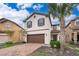 Two-story house with brown garage door and brick driveway, surrounded by palm trees at 5505 Misty Oak Cir, Davenport, FL 33837