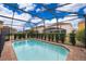 Refreshing screened pool with surrounding brick patio at 5505 Misty Oak Cir, Davenport, FL 33837