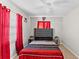 Bedroom with gray upholstered bed and red bedding set at 7804 Acadian Dr, Orlando, FL 32822
