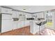 Kitchen with white cabinets, tile floor, and a breakfast bar with three stools at 7804 Acadian Dr, Orlando, FL 32822