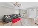 Bright living room featuring a gray sectional sofa, red rug, and tile floors at 7804 Acadian Dr, Orlando, FL 32822