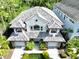 Overhead view of gray roof, two-story home featuring a well-manicured front yard, and a two-car garage at 8162 Valhalla Ter, Reunion, FL 34747