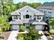 Aerial view of luxury home featuring manicured landscaping, brick driveway, and a beautiful tile roof at 8162 Valhalla Ter, Reunion, FL 34747