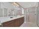 Elegant bathroom with double vanity, large mirror, and walk-in shower at 8162 Valhalla Ter, Reunion, FL 34747