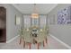 Elegant dining room with a round glass table, light green chairs, and lovely artwork at 8162 Valhalla Ter, Reunion, FL 34747
