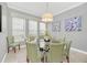 Charming dining room features a round table, light green chairs, and large windows at 8162 Valhalla Ter, Reunion, FL 34747