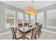 Bright dining room features a glass-top table and eight chairs, with large windows and a modern light fixture at 8162 Valhalla Ter, Reunion, FL 34747