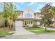 Two-story house with a two-car garage and lush landscaping at 8162 Valhalla Ter, Reunion, FL 34747