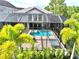 Screened-in pool area with hot tub and plenty of space for entertainment and surrounded by tropical palm trees at 8162 Valhalla Ter, Reunion, FL 34747