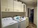 Laundry room with washer, dryer, and cabinets at 26 Lake Diamond Ave, Ocala, FL 34472