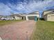 Two-car garage with paver driveway and lush lawn at 11880 Campfire Story Ln, Orlando, FL 32832