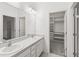 Bathroom featuring a double sink vanity, a large mirror, and a walk-in closet at 1311 E 10Th St, Apopka, FL 32703