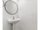 Small bathroom with stand-alone sink, round mirror and white walls at 1311 E 10Th St, Apopka, FL 32703