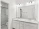 Bright bathroom featuring a double sink vanity, a large mirror, and a glass-enclosed shower at 1311 E 10Th St, Apopka, FL 32703