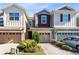 Three-story townhouses with attached garages and landscaped front yards at 1311 E 10Th St, Apopka, FL 32703
